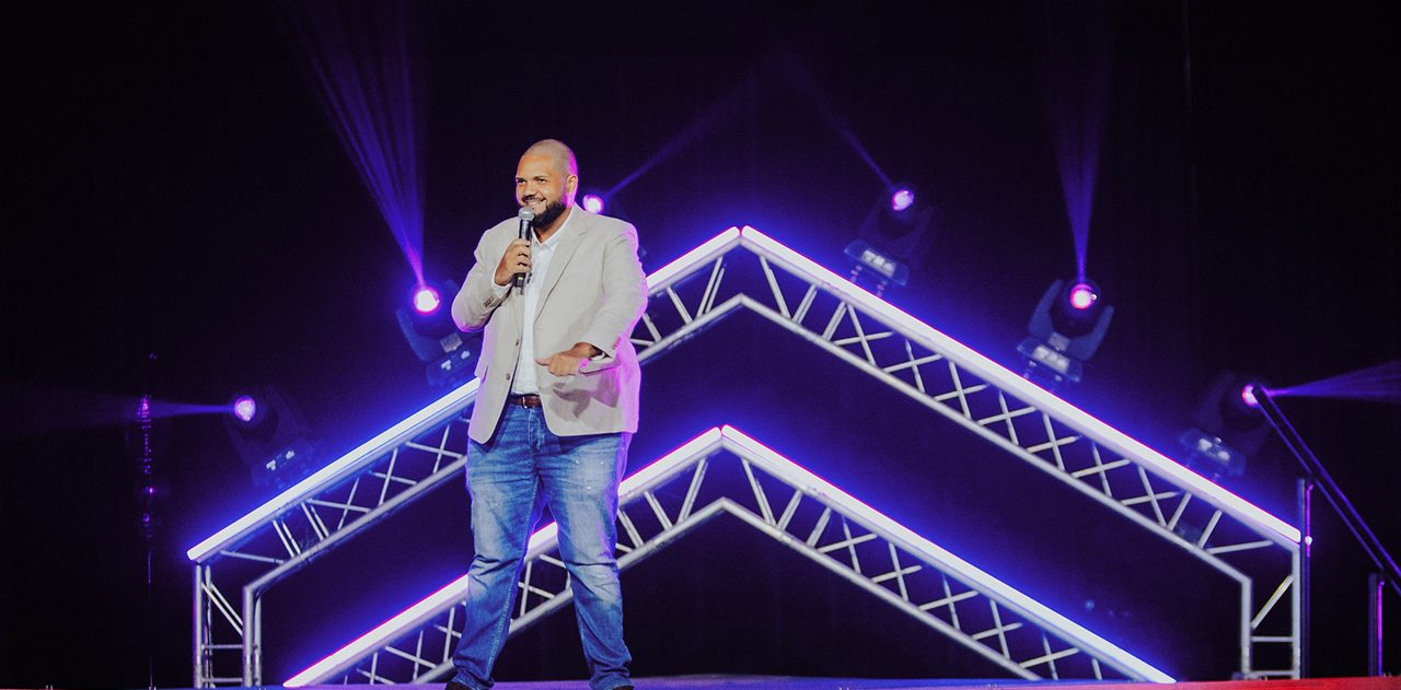 Speaker on stage under violet lights